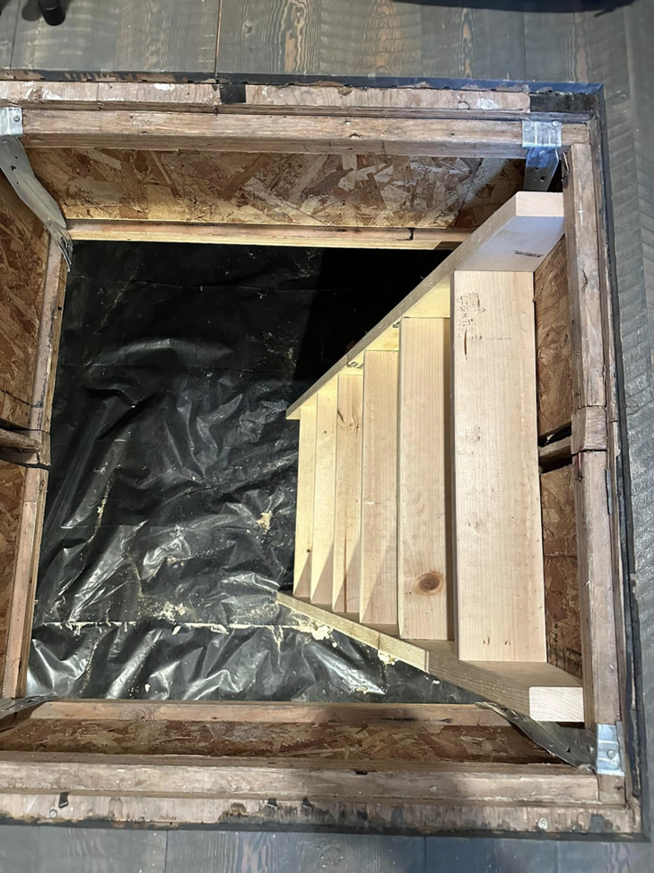 Wooden stairs installed in a floor opening for access to a lower level by Blue Heron Property Care LLC in Kalispell, MT