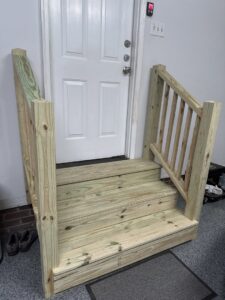 Newly built wooden steps and railing leading to a door, installed by Home FREA in Raleigh, NC.