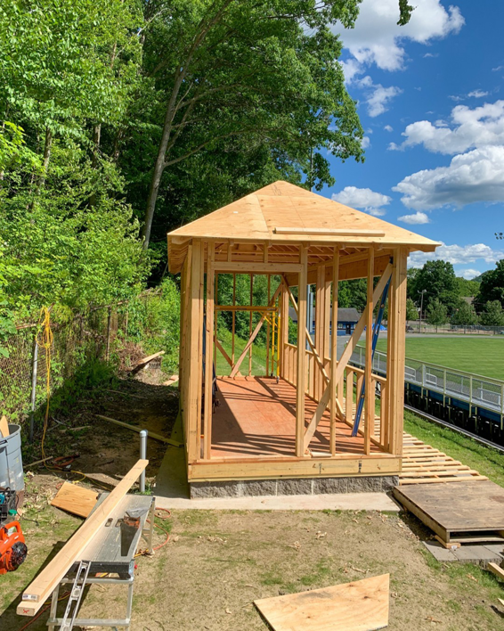 Wooden framing of a small outdoor structure under construction, showing the roof and wall studs, by Yellow Ladder Contracting in Mount Pleasant, SC