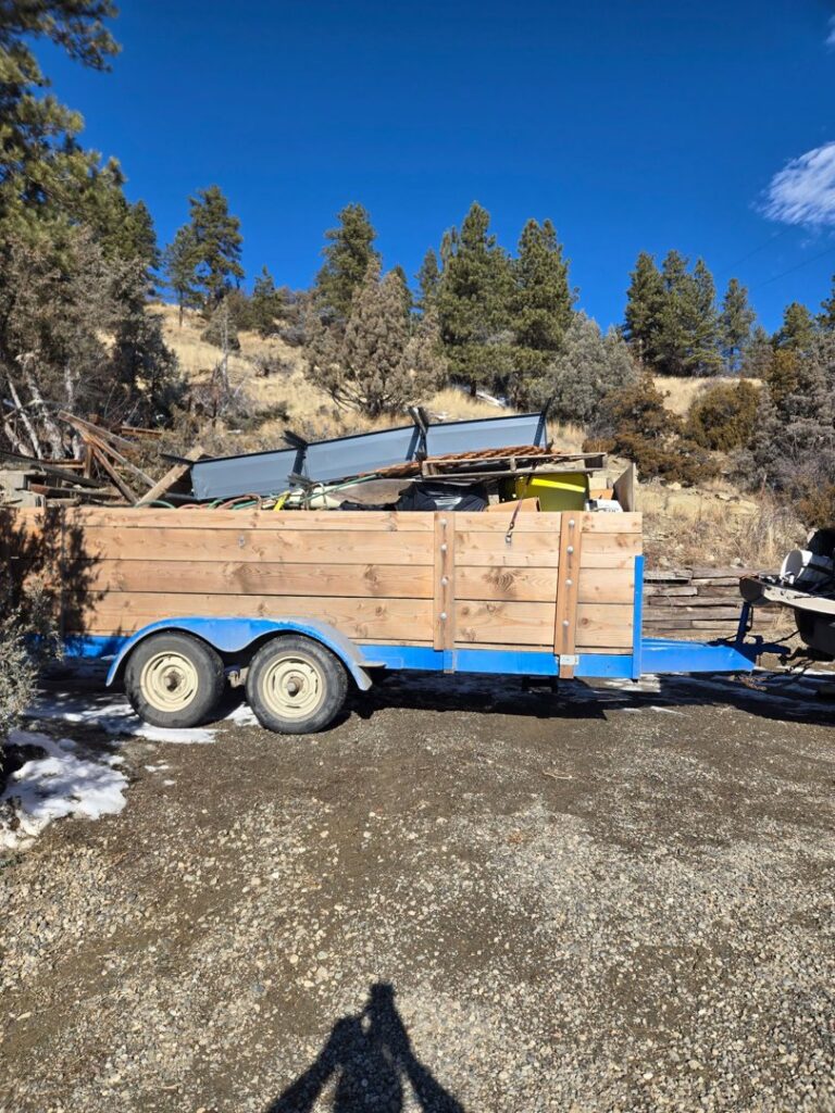 A wooden trailer loaded with construction debris and metal items for removal by Big Sky Junk Removal LLC in Billings, MT.