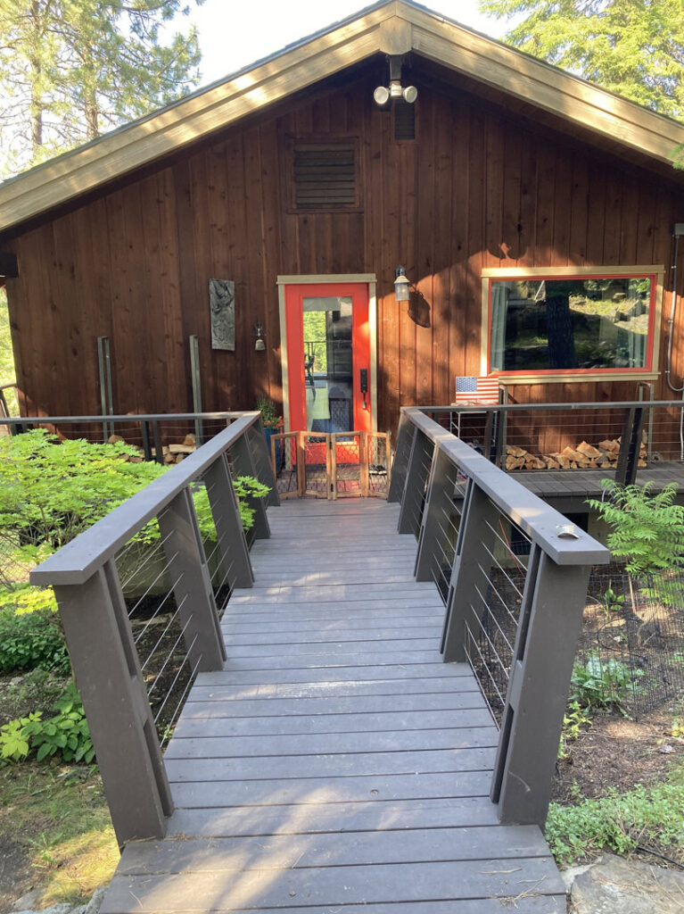 A rustic house with a newly built wooden walkway and bridge leading to the front door by Top Shelf Handyman Pros in Post Falls, ID