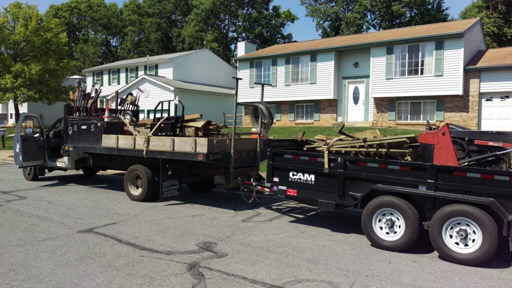 A work truck with a trailer loaded with tools and materials for Quality Fence & Deck Co. in Frederick, MD.