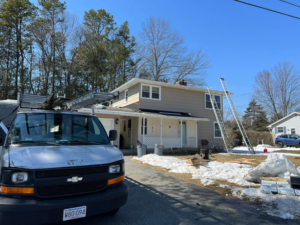 A work van and ladders ready for a handyman service at a house by Rambo'S Construction Inc in Brockton, MA