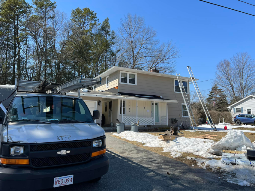 A work van and ladders ready for a handyman service at a house by Rambo'S Construction Inc in Brockton, MA