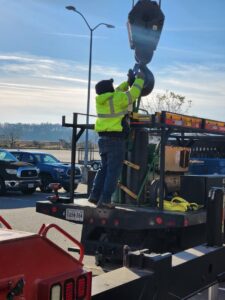 A worker from Tidewater Crane & Contracting adjusting a crane hook on a truck in Virginia Beach, VA
