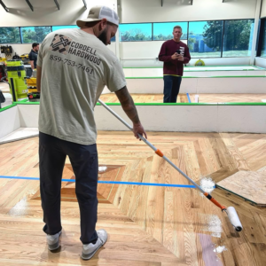 A worker from Cordell Hardwood Flooring applying a protective finish to a newly installed hardwood floor in Lexington, KY.