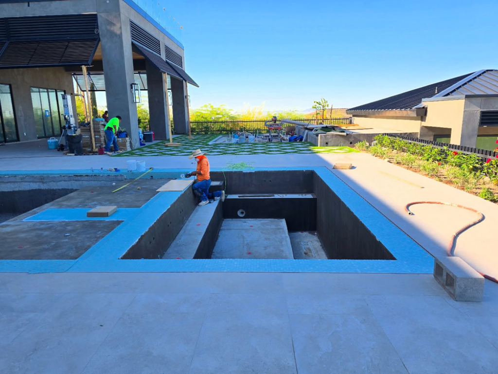 A worker applying material to a pool step during construction by Premier Paradise, Inc. in Gilbert, AZ.