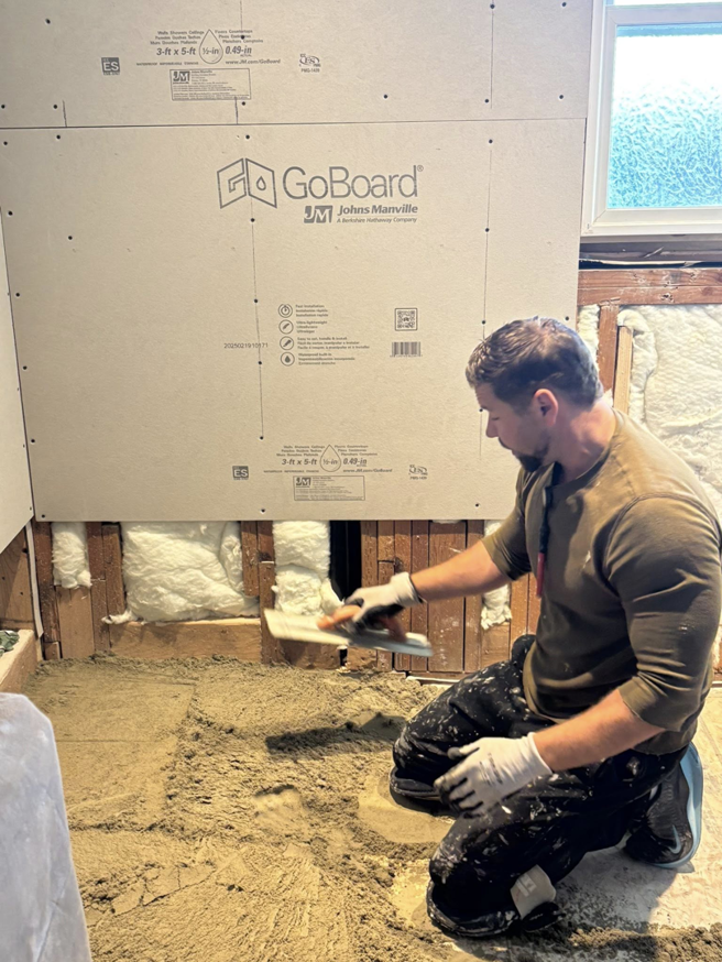 A worker applying mortar for tile preparation by Gregg Hoffman Construction Inc. in Tacoma, WA