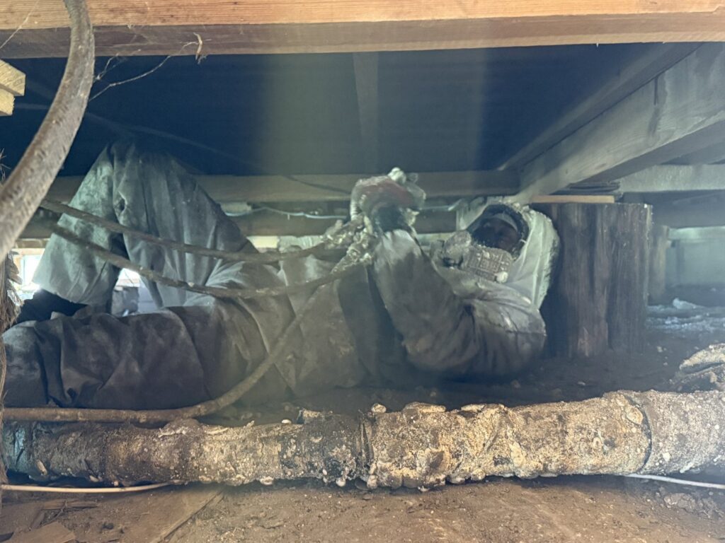 Worker in protective gear applying spray foam insulation in a crawl space for IFOAM Insulation of Hill Country in San Antonio, TX
