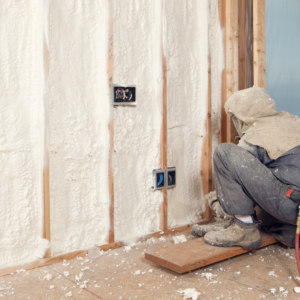 A worker applying spray foam insulation to wall studs for Lantz Insulation Inc in Bird In Hand, PA.