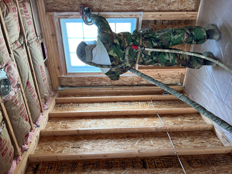 An Insulation Man worker applying spray foam insulation to a ceiling in a residential property in Chesterfield, MI.