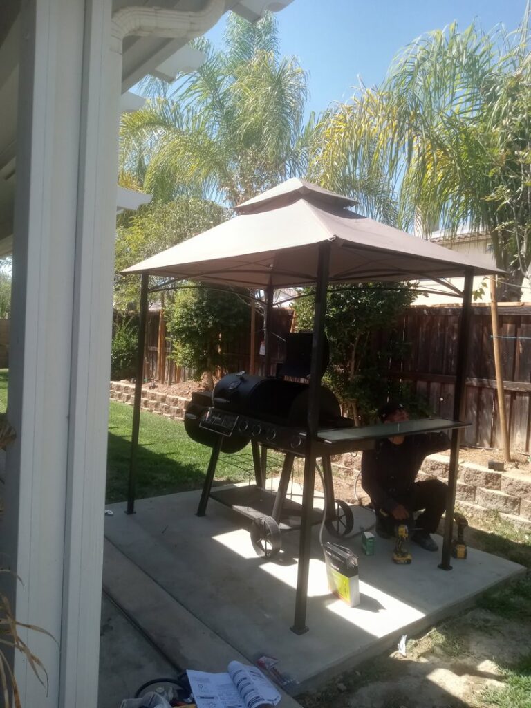 A worker assembling an outdoor gazebo with a grill, a construction project by Juancho's Handyman in Salida, CO.