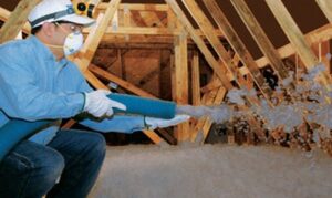A worker blowing insulation into an attic for Mincin Insulation Service Inc. in Pittsburgh, PA