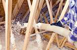 A worker blowing loose-fill insulation into an attic or wall cavity for Ohio Insulation & Manufacturing Co in Dayton, OH.