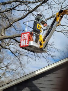 A Capital Tree Company worker in a bucket lift performing tree trimming services in Des Moines, IA.