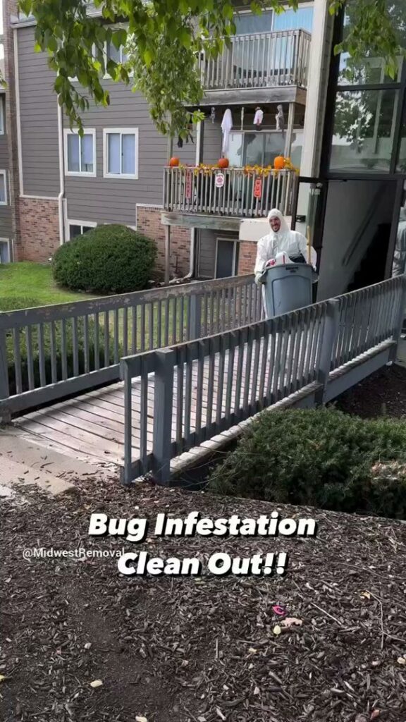 A Midwest Removal worker in a hazmat suit performing a bug infestation clean out service in Omaha, NE.