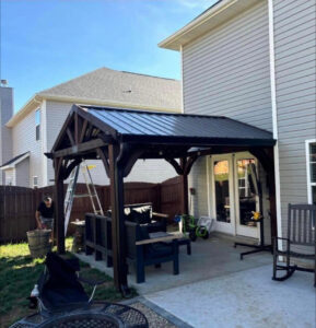 Worker building a patio pergola, a home improvement project by Knoxville Guttering and Home Improvements in Knoxville, TN.