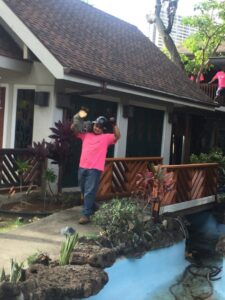 A Starfarm Tree Service Hawaii worker carrying a heavy log section during a tree removal job in Kapolei, HI.
