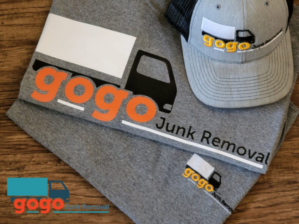 A GoGo Junk Removal worker cleaning a very messy room filled with trash and debris in Atlanta, GA.