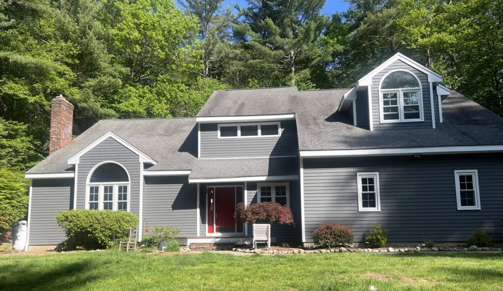 A worker on a ladder performing gutter cleaning and repair for Casanova Remodeling in Plymouth, CT.