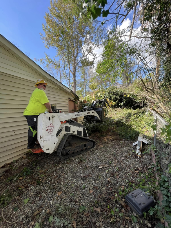 A worker clearing brush and debris with a Bobcat compact track loader for A Cut Above Tree and Crane in Carrollton, VA.