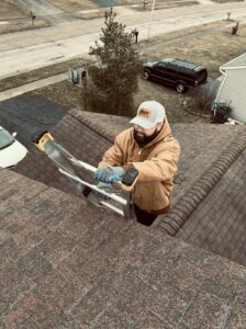A SHIFT Roofing & Exteriors worker climbing a ladder onto a residential roof in Gahanna, OH
