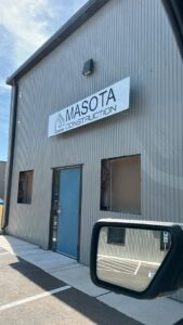 A worker on a commercial rooftop performing maintenance or installation on HVAC or electrical conduits for Masota Construction in El Paso, TX.