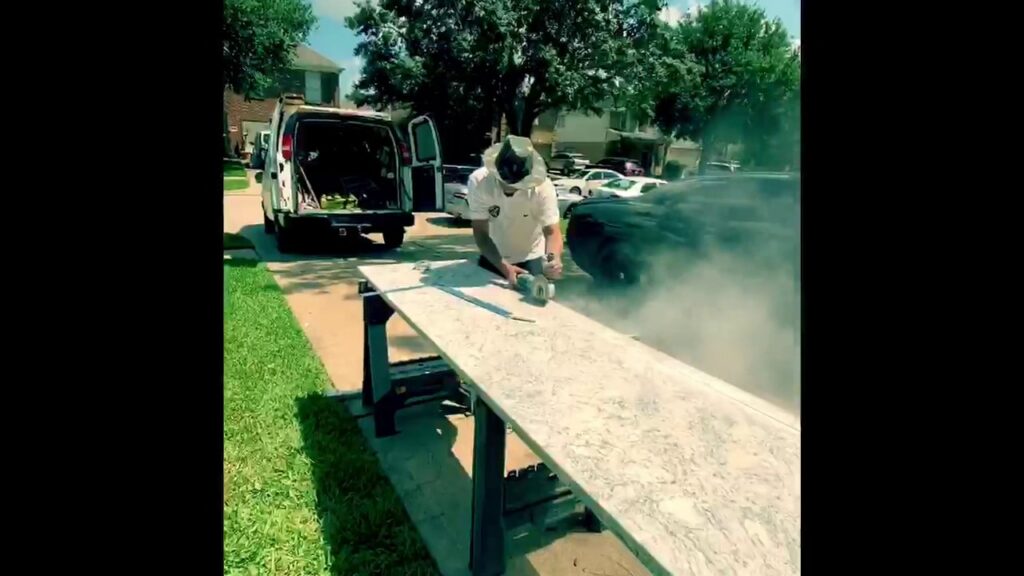 A worker cutting a kitchen countertop outdoors for MC Master Construction in League City, TX