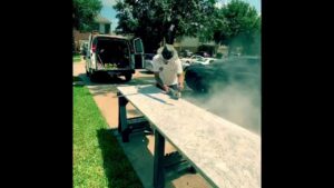 A worker cutting a kitchen countertop outdoors for MC Master Construction in League City, TX