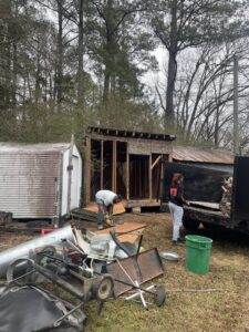 A worker using a power saw to cut wood during a shed construction or repair project by Ed Hauls It All in Raleigh, NC.