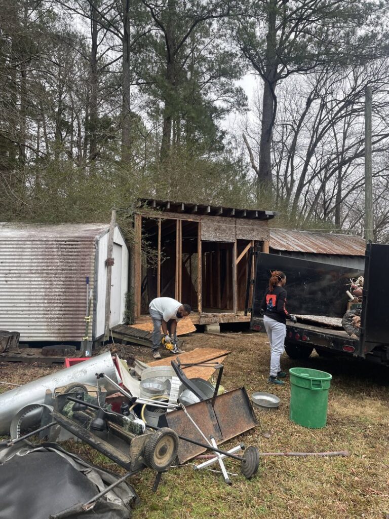 A worker using a power saw to cut wood during a shed construction or repair project by Ed Hauls It All in Raleigh, NC.