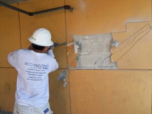 A worker demolishing a wall surface with a jackhammer for Vico Painting Contractors in Hialeah, FL