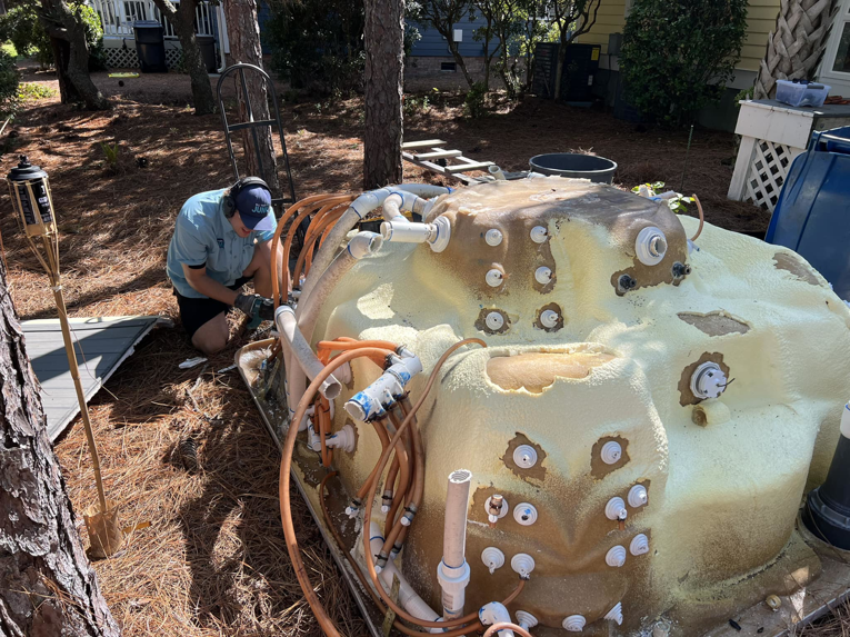 A worker dismantling an old hot tub for removal by All That Junk Removal in Wilmington, NC.