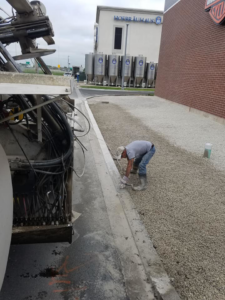A worker finishing a concrete curb, demonstrating general contractor services by National Kurb Kut in Naperville, IL.