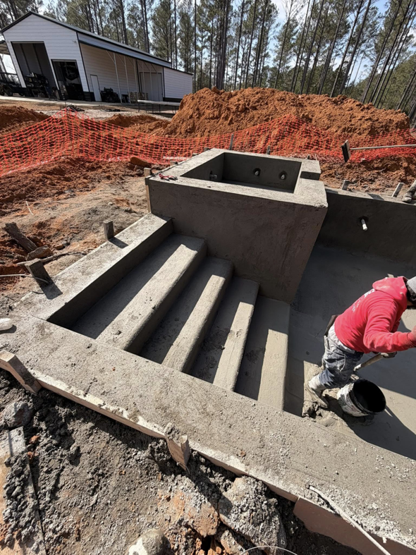 A worker finishing concrete on the steps and spa area of a pool project by Ga Impact Shotcrete in Atlanta, GA.