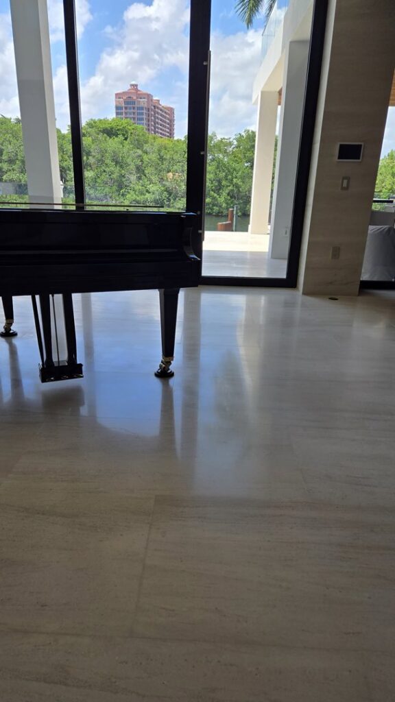 A worker operating a floor grinding machine on a concrete floor at a construction site, performed by Cornerstone Services Management in Miami, FL.