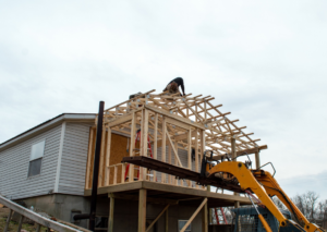 A worker framing a new house addition, demonstrating construction services by Naugle Construction Company in Columbia, MO.