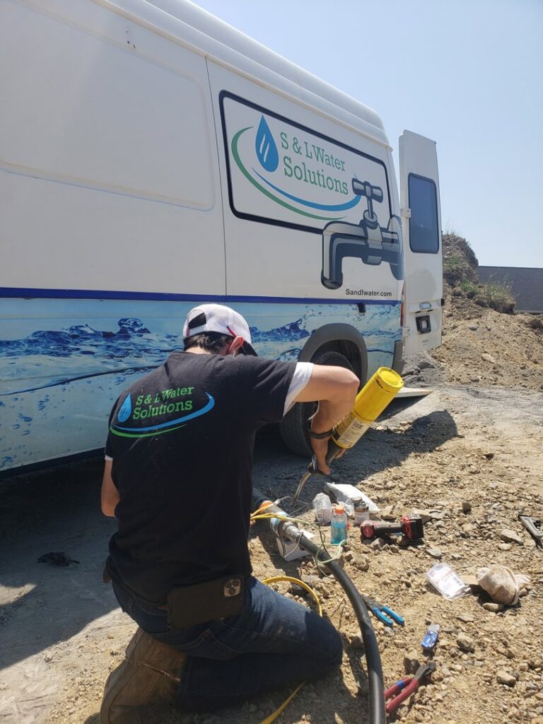 A worker handling equipment on a service truck for a job by S & L Water Solutions in Hagerstown, MD.
