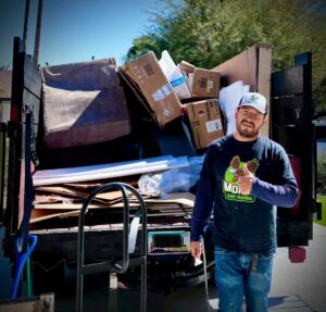 A Mora's Junk Removal & Hauling llc. worker hauling bricks in a wheelbarrow at a job site in Scottsdale, AZ