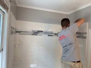 A worker from Prenga Remodeling installing bathroom tile in Orange, CT