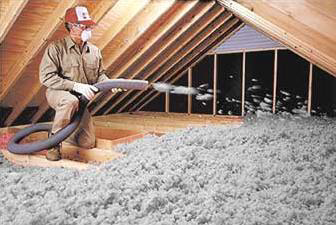 A worker installing blown-in insulation in an attic space for Weathertite Insulation in Oshkosh, WI.