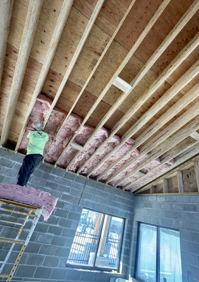 A worker installing insulation in a ceiling for ADDICT INSULATION, LLC in St. Charles, MO.