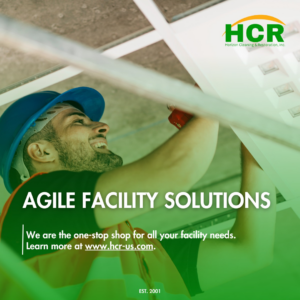 A worker installing ceiling panels as part of facility solutions provided by HCR, Inc. in Boerne, TX.