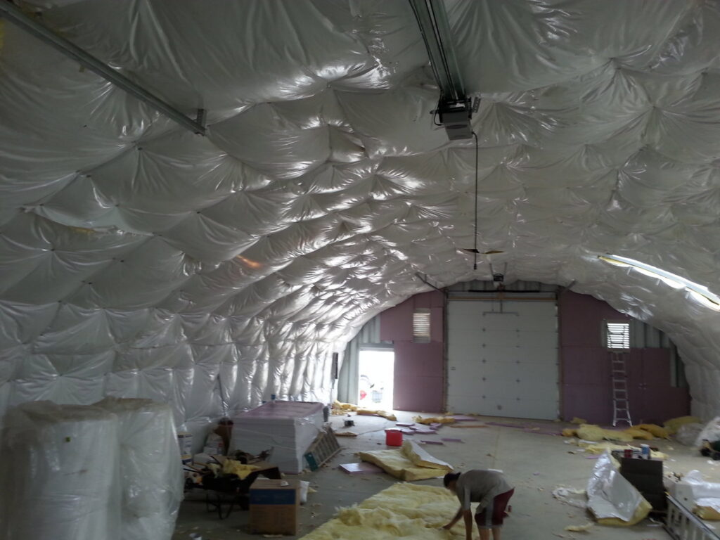 A worker installing insulation in a large commercial building for ADDICT INSULATION, LLC in St. Charles, MO.