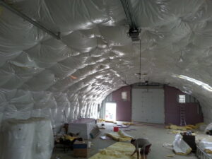 A worker installing insulation in a large commercial building for ADDICT INSULATION, LLC in St. Charles, MO.