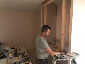 A worker installing interior framing for a built-in structure by Prenga Remodeling in Orange, CT