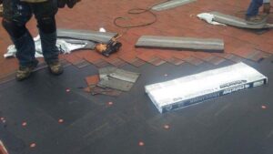 A worker installing new roof shingles with a nail gun for Villalobos Remodeling & Construction in El Paso, TX