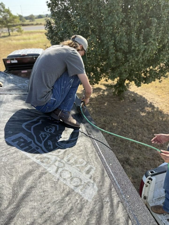 A worker installing roofing underlayment for Hansen Construction Stillwater in Stillwater, OK.