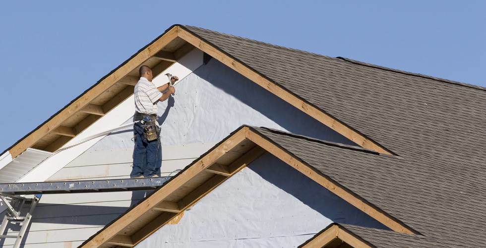 A construction worker installing siding on a new house build by JON Construction, Inc. in Allentown, PA.