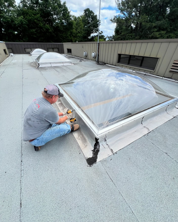 A worker installing a new skylight on a commercial roof for Elite Roofing Solutions in Bartlett, TN.